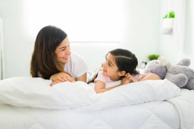 Çocuklarım benim her şeyim. Güzel, genç bir anne ve tatlı bir ilkokul kızı. Birbirlerine bakıyorlar ve rahat bir yatakta yatarken gülümsüyorlar.