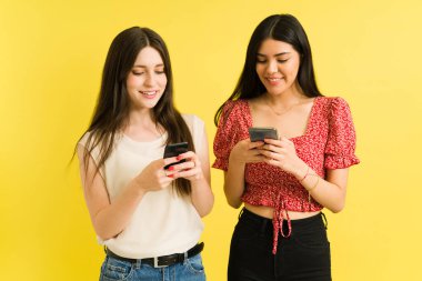 Bazı ilginç dedikoduları paylaşıyoruz. İki güzel arkadaş akıllı telefonlarını tutuyor ve yan yana dururken mesajlaşıyorlar. 