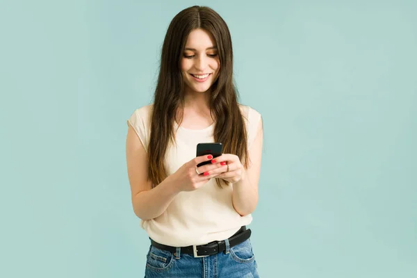 아름다운 여성이 웃으면서 친구들에게 문자를 보내면서 스마트폰을 있습니다 그녀의 파트너로부터 — 스톡 사진
