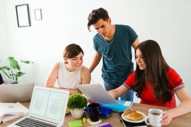 Üniversite arkadaşları 20 'li yaşlarda ödevlerini teslim etmeden önce akademik bir makale okuyorlar. Üniversite öğrencileri evde birlikte okuyorlar.