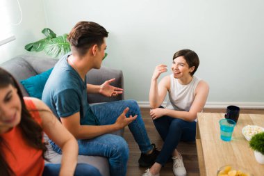 Neşeli genç bir kadın üniversiteli bir adamla gülüp flört ediyor. Çeşitli arkadaşlar oturma odasında beraber takılıp oturuyorlar. 