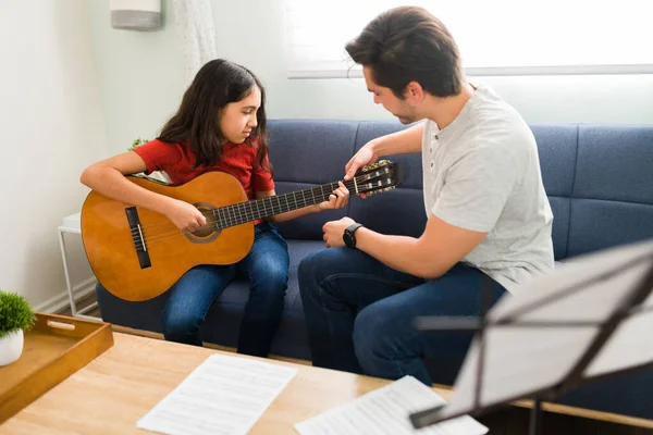 基本的なギターコード ホームレッスン中に男性教師と新しい楽器を学び 練習するプリティーガール — ストック写真
