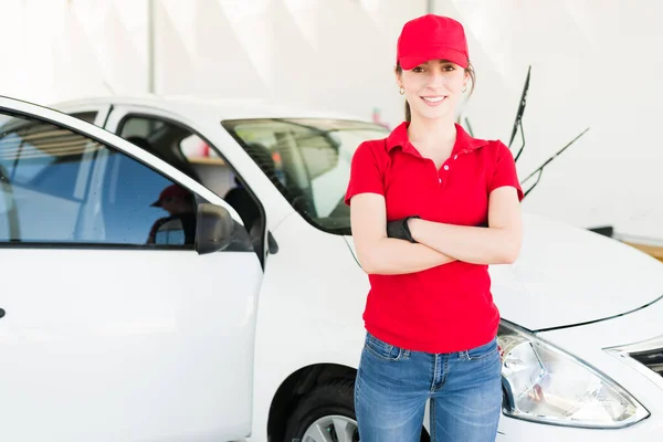 Feeling proud of my work at the car wash. Portrait of a beautiful female worker smiling and taking a break from her job at the auto detail service