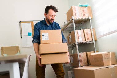 Büyüyen bir online atölyesi olan çalışkan bir işletme sahibi. Küçük ofisinde paketleri düzenleyen çekici bir girişimci. 