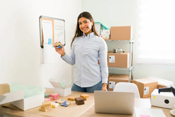 Happy to be starting my own business. Portrait of a beautiful female boss showing her organic and natural beauty products from her online shop