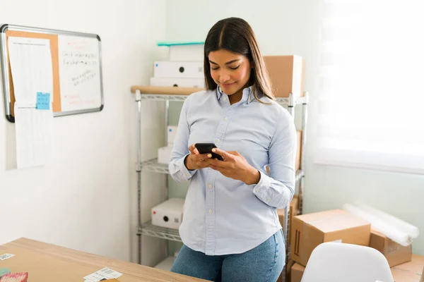 休息和检查工作中的社交媒体 在她的商务办公室工作时 迷人的年轻女性一边笑着一边用智能手机发短信 — 图库照片