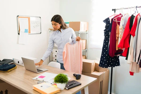 Çevrimiçi moda işi yapan genç bir bayan girişimci. İspanyol çekici kadın müşterilerin siparişleri için paketler hazırlıyor.