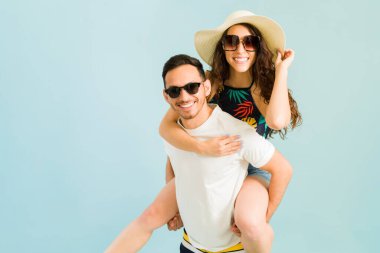 Yaz tatilinde gülümseyen ve kız arkadaşını sırtında taşıyan yakışıklı bir İspanyol 'un portresi.