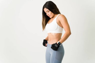 Güçlü bir karın kasları olması için spor yapan bir kadın. Ve kaslarını gösteriyor. Spor kıyafetli genç sporcu karın kaslarını çalıştırıyor.