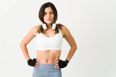 Zorlu bir antrenman yapmaya hazırım. Egzersiz yapmak üzere olan kulaklıklı sporcu bayan sporcu. İnce vücutlu genç bir kadın.