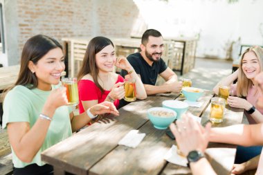 Çekici genç arkadaşlar gülerek ve hayatlarından bahsederek barda biraz içki ve bira içerek eğleniyorlar. 