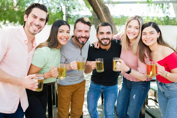 友情の再会 20代の笑顔で目を見張りながらビールを楽しみながら交流する魅力的な仲間たちの姿 — ストック写真