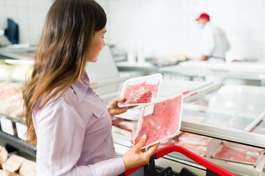 Akşam yemeği için bir şey almak istiyorum. Arkasından marketten çiğ et ya da biftek alırken görülen çekici bir kadın.