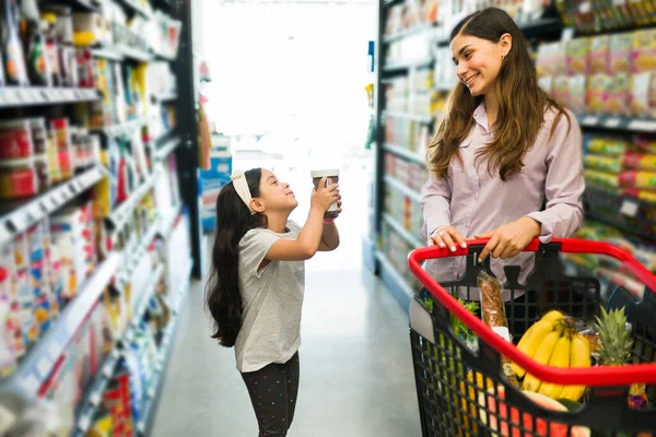 请给我买巧克力 可爱的小女孩让她漂亮的妈妈去超级市场买她的榛子奶油当早餐 — 图库照片
