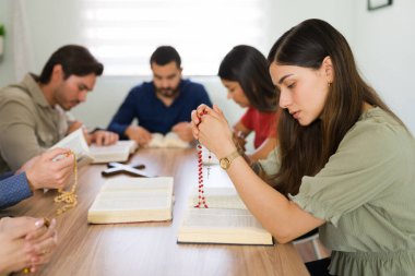 Çok inançlı, dini bir gruba dua eden güzel bir İspanyol kadının profili. Genç Katolik kadın elinde bir tespih tutuyor ve af diliyor. 