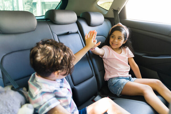 Да, мы сделали это! Латиноамериканская младшая сестра и брат отсиживают пять минут в машине после того, как их родители согласились отвести их в парк поиграть