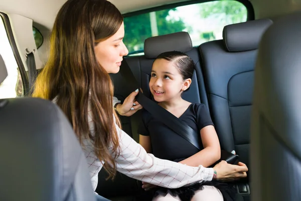 安全是非常重要的 有爱心的年轻妈妈给他的小女儿系上安全带 开车送她去上芭蕾舞课 — 图库照片