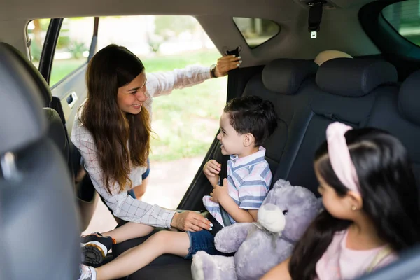 快乐的妈妈和小男孩在车上系上安全带后 面带微笑地互相致意 — 图库照片