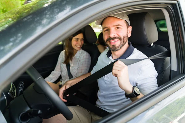 安全第一 30代のハンサムな男は休日のためにビーチに彼の家族を運転する前にシートベルトに置く — ストック写真