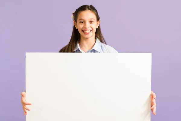 Encantadora Jovencita Mirando Cámara Sonriendo Mientras Sostiene Gran Cartel Blanco —  Fotos de Stock