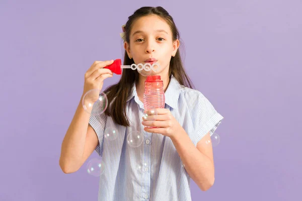 享受泡泡的乐趣 可爱的小女孩玩玩具 在明亮的紫色背景下吹泡泡 — 图库照片