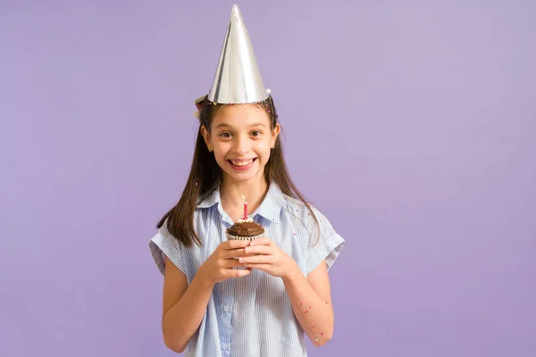 Menina Animada Usando Chapéu Festa Segurando Cupcake Chocolate Com Uma — Fotografia de Stock