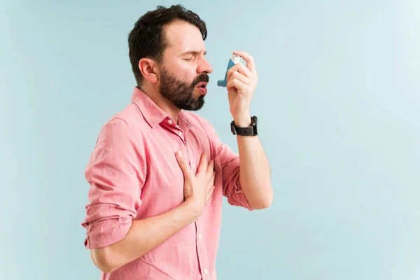 有呼吸问题的英俊男子用吸入器治疗哮喘 拉丁男人不能呼吸和摸他的胸部 — 图库照片