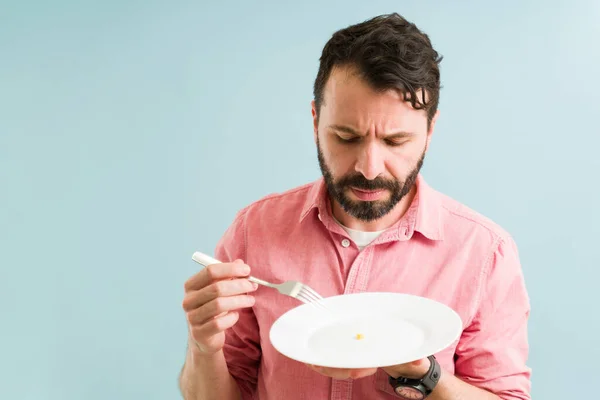 我不能吃这个 食欲不振的男人看着他的饭碗 试着吃午饭 — 图库照片