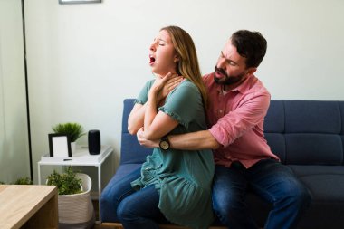 Stresli Latin adam, genç kız arkadaşının kanepede birlikte otururken boğulması üzerine Heimlich manevrası yapıyor. 