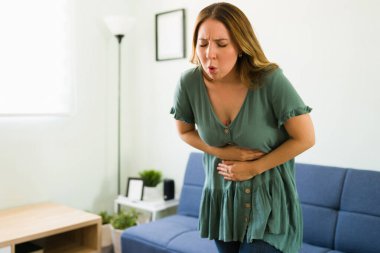 Üzgün genç bir kadın kusmak için tuvalete gidiyor ve evinde mide enfeksiyonu geçiriyor.