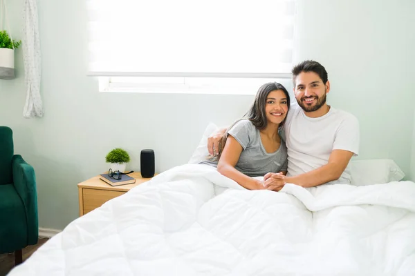 一对恋爱中的年轻夫妇牵着手在床上拥抱 同时进行眼神交流的画像 西班牙男人和女人正准备睡觉 — 图库照片