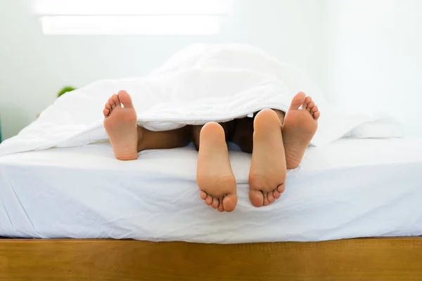 Acercamiento Los Pies Una Joven Pareja Acostada Cama Bajo Las — Foto de Stock