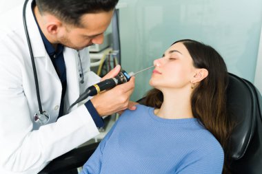 Sinüzit teşhisi. İspanyol otolarolog bir kadın hastayı burun enfeksiyonu nedeniyle laparoskopla muayene ediyor.