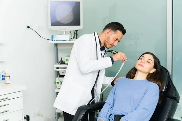 Médico Otorrinolaringólogo Latino Mirando Canal Auditivo Una Paciente Con Laparoscopio —  Fotos de Stock