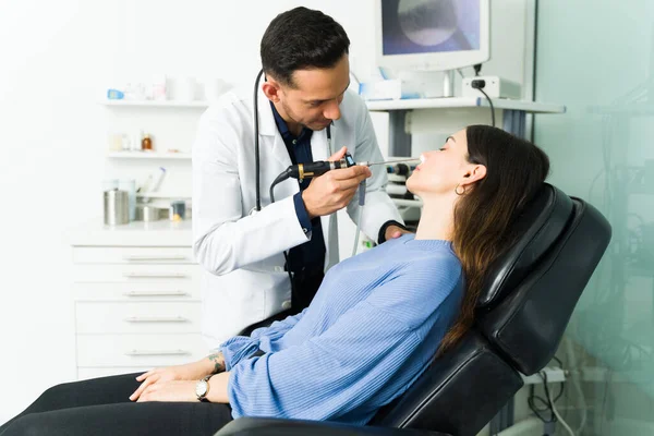 一位专业耳鼻喉科医生用腹腔镜检查一位有呼吸问题的年轻女性的侧视 — 图库照片