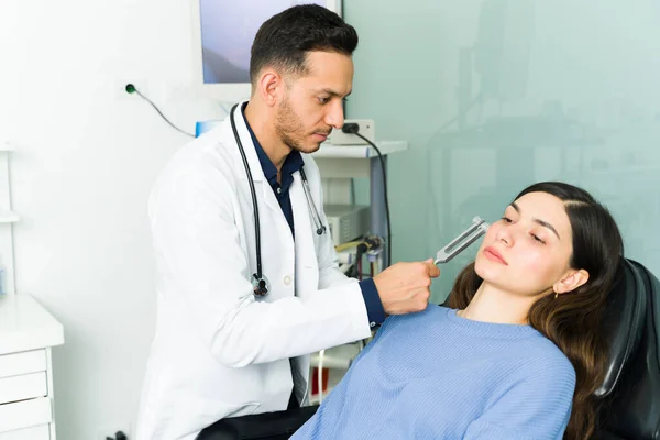 Getting a medical diagnosis for my hearing problems. Young woman patient with hearing problems visiting the otolaryngologist's office