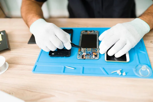 Técnico Latino Segurando Algumas Pinças Consertando Hardware Danificado Smartphone Quebrado — Fotografia de Stock