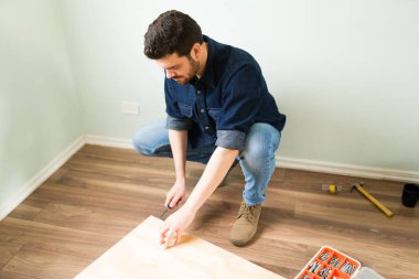 Çekici bir adam ve tamirat sırasında ahşap döşeme mobilyası yapımında çalışan tamirci.
