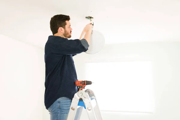 Hispanic Homeowner Stepping Ladder Home While Repairing Electrical System Light — Stock Photo, Image