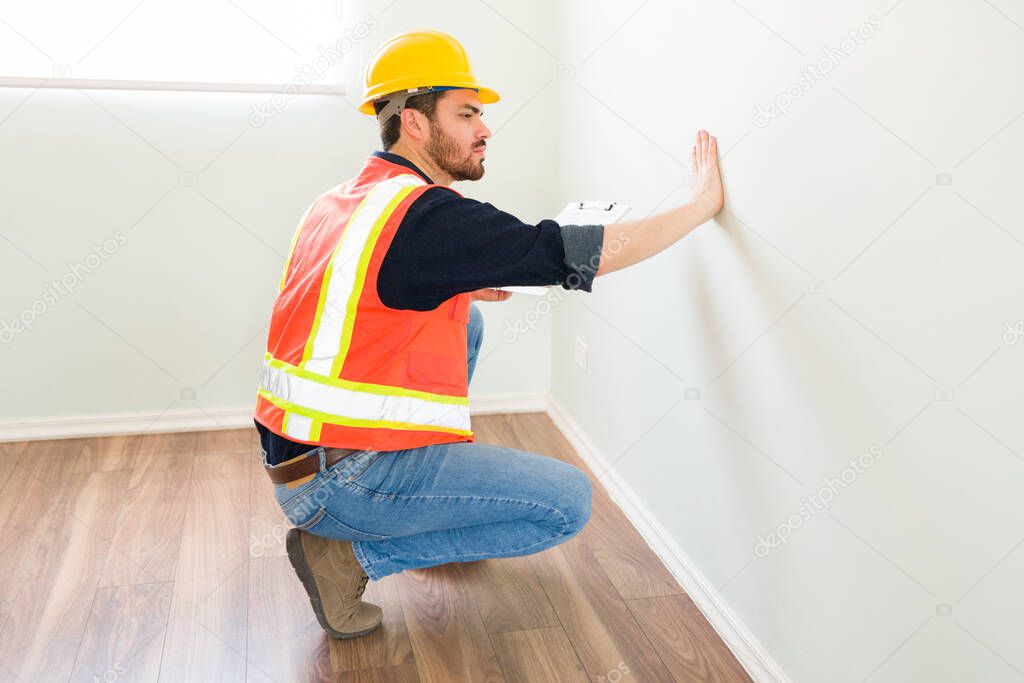 Professional construction expert touching and checking the new walls after doing home renovations 