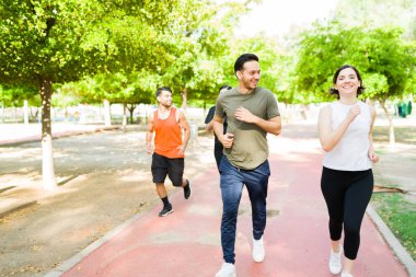 Birlikte koşmaya bayılıyoruz. 20 'li yaşlarda çekici bir arkadaş grubu gülümsüyor ve parkta koşuya çıkıyorlar. 