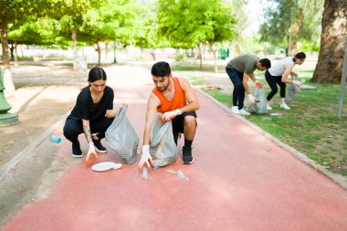 Temiz bir park istiyorum. 20 'li yaşlarda bir grup sorumluluk sahibi arkadaş birlikte egzersiz yaparken dışarıda çöp topluyor.