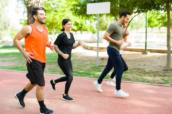 享受在公园里跑步的乐趣 西班牙裔朋友们穿着运动服在室外跑步公园里嬉笑和慢跑 — 图库照片