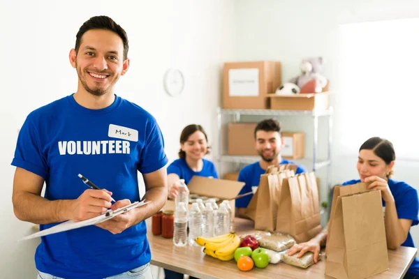 Retrato Apuesto Voluntario Supervisor Sosteniendo Portapapeles Mientras Revisa Línea Trabajo — Foto de Stock