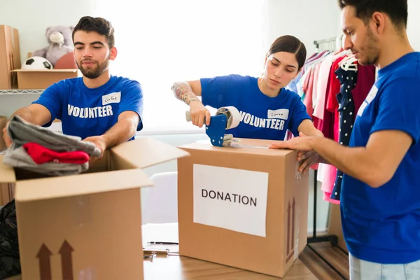 Atractivos Jóvenes Sellando Cajas Donaciones Con Cinta Adhesiva Voluntarios Hispanos — Foto de Stock
