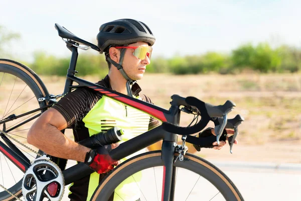 职业运动员带着安全帽和带着自行车的运动型太阳镜 拉丁自行车手准备开始踩踏 — 图库照片