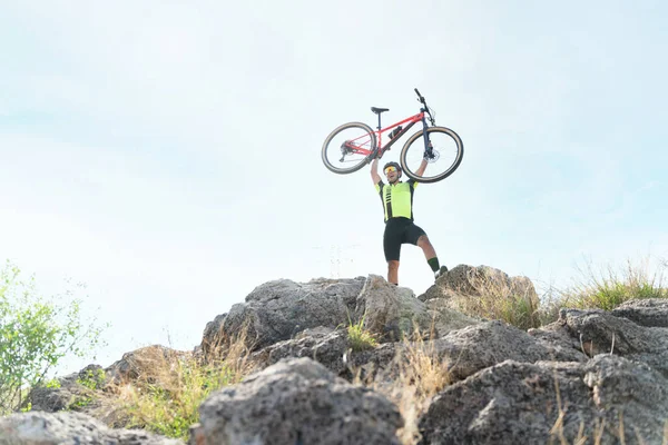 俺が作ったんだ 男の自転車を頭の上に担いで 山道を走り終えた後の幸せを叫びながら興奮するサイクリスト — ストック写真