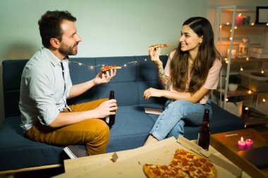 Yakışıklı bir adam ve genç bir kadın evde romantik bir şekilde buluşuyorlar. Pizza yiyip bira içen çekici bir çift. 