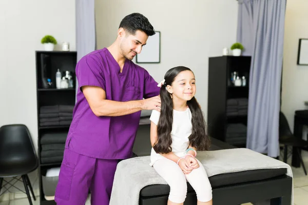 Ein Lateinischer Männlicher Physiotherapeut Gibt Einer Kleinen Patientin Eine Schultermassage — Stockfoto