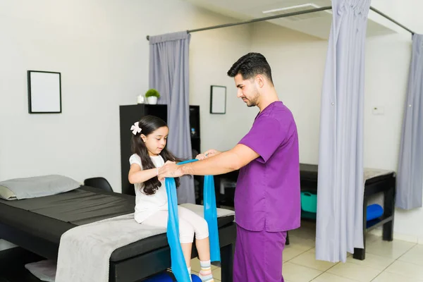 Ragazza Elementare Ispanica Dal Fisioterapista Che Tiene Una Fascia Resistenza — Foto Stock